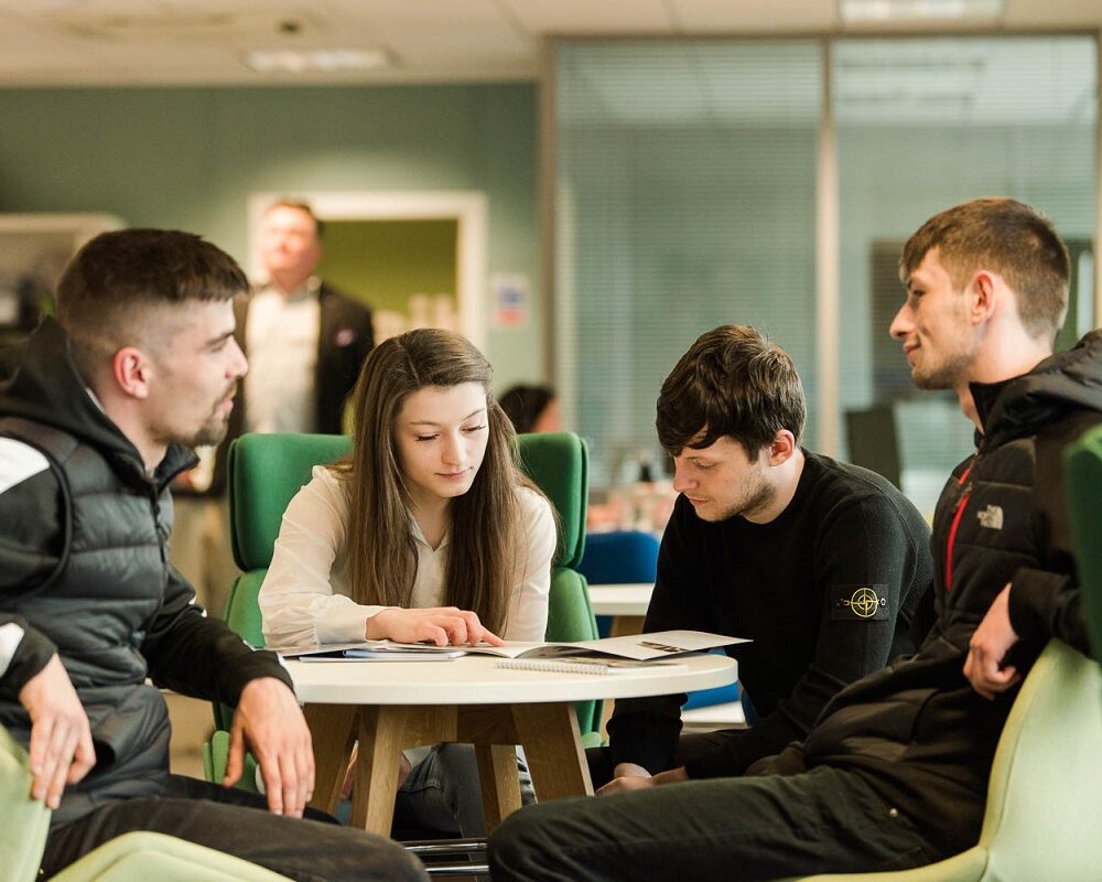 group of people talking and looking at brochures