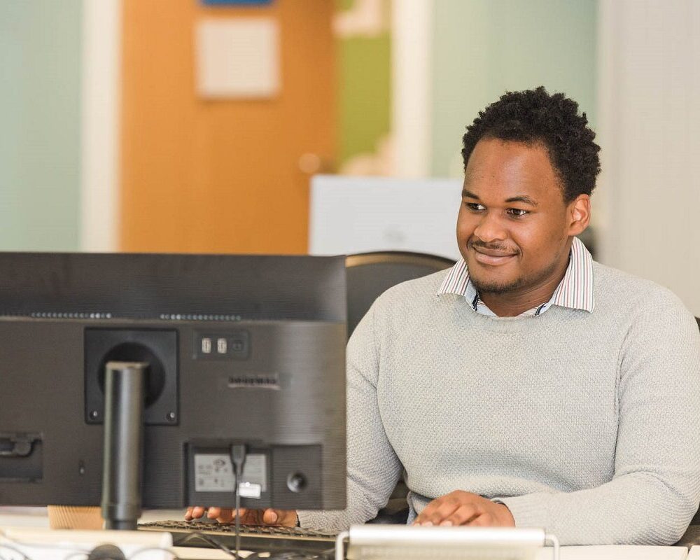 Man looking at a computer screen smiling